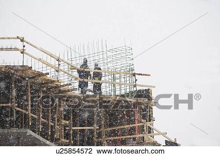 Stock Image - USA, New York City, construction site in snowstorm. Fotosearch