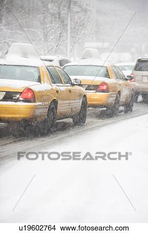 Picture - USA, New York City, yellow cabs on snowy street. Fotosearch