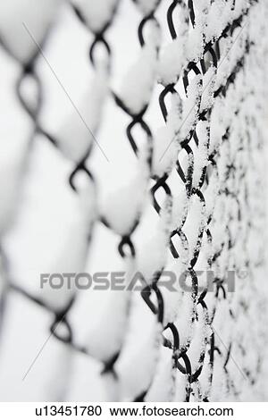 Stock Image - USA, New York State, Brooklyn, Williamsburg, snow covered chainlink fence. Fotosearch
