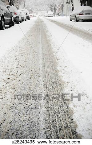Stock Photography - USA, New York State, Brooklyn, Williamsburg, tire track on snow covered street. Fotosearch