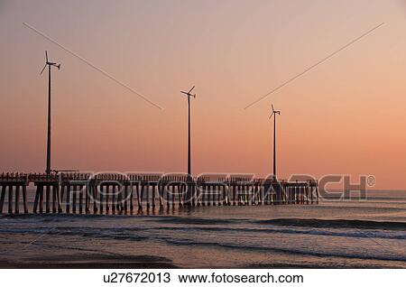 USA, North Carolina, Outer Banks, Kill Devil Hills, pier with wind turbines at sunset View Large Photo Image Stock Image - USA, North Carolina, Outer Banks, Kill Devil Hills, pier with wind turbines at sunset. Fotosearch
