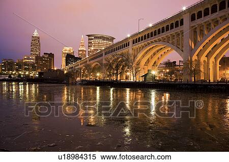 Stock Photography - USA, Ohio, Bridge crossing Cuyahoga River at dusk Cleveland. Fotosearch