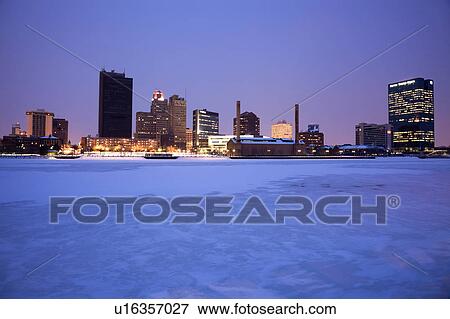 Stock Photo - USA, Ohio, Toledo skyline across frozen river, dusk. Fotosearch