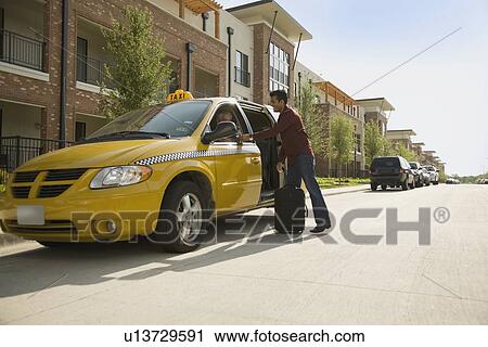 Stock Image - USA, Texas, Dallas, Man alighting from taxi. Fotosearch