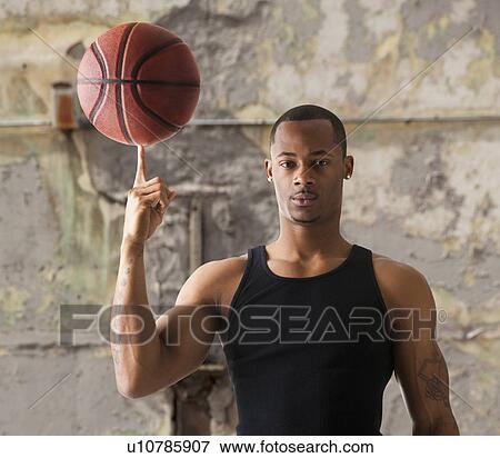 Stock Photo - USA, Utah, Salt Lake City, Portrait of young man with basketball. Fotosearch