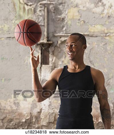 Stock Photo - USA, Utah, Salt Lake City, Young man playing basketball. Fotosearch