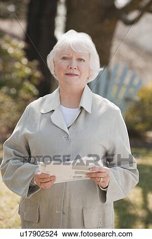 Picture - USA, Virginia, Richmond, portrait of senior woman holding bills. Fotosearch