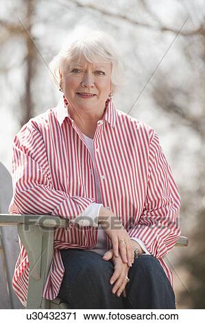 Stock Image - USA, Virginia, Richmond, portrait of senior man in adirondack chair. Fotosearch