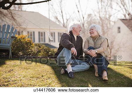 Stock Photograph - USA, Virginia, Richmond, senior couple relaxing on grass. Fotosearch