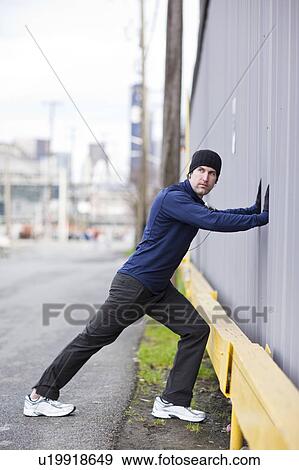 Stock Photo - USA, Washington, Seattle, man in sports clothing exercising. Fotosearch