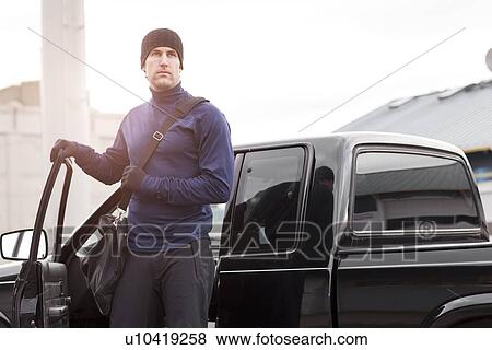 Stock Photo - USA, Washington, Seattle, man in workout wear getting out of truck. Fotosearch