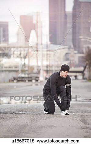 USA, Washington, Seattle, man tying shoelace in street View Large Photo Image Stock Photo - USA, Washington, Seattle, man tying shoelace in street. Fotosearch