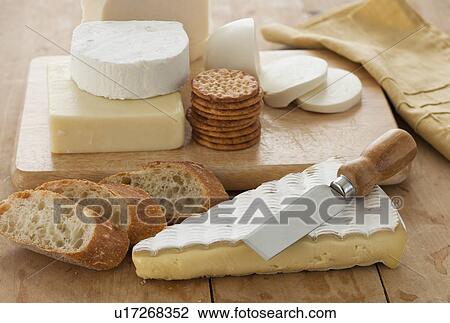 Various cheeses and bread on table View Large Photo Image Stock Image - Various cheeses and bread on table. Fotosearch