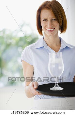 Stock Photo - Waitress holding tray with glass. Fotosearch