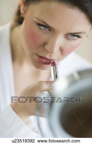 Stock Image - Woman applying lipstick. Fotosearch