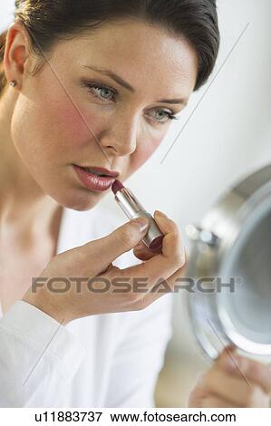 Stock Photo - Woman applying lipstick. Fotosearch