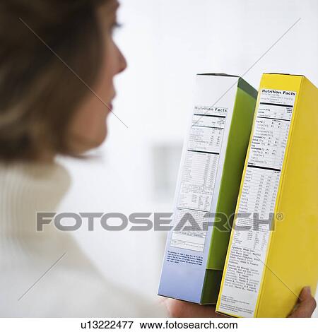 Woman comparing nutrition labels View Large Photo Image Stock Photo - Woman comparing nutrition labels. Fotosearch