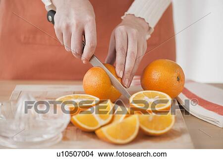 Picture - Woman cutting oranges. Fotosearch