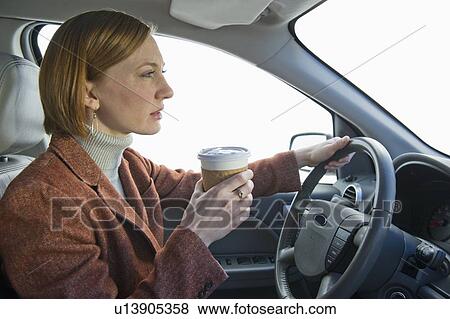 Woman driving car and drinking coffee View Large Photo Image Stock Photo - Woman driving car and drinking coffee. Fotosearch
