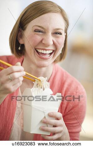 Stock Image - Woman eating Chinese take out food. Fotosearch