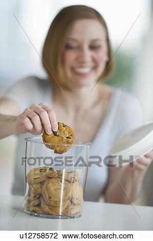 Stock Image - Woman eating cookies. Fotosearch