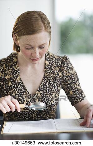 Stock Image - Woman examining documents. Fotosearch