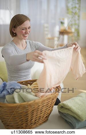 Stock Photography - Woman folding laundry. Fotosearch