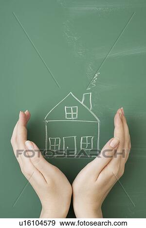 Woman holding hands around house drawn on blackboard View Large Photo Image Stock Photo - Woman holding hands around house drawn on blackboard. Fotosearch