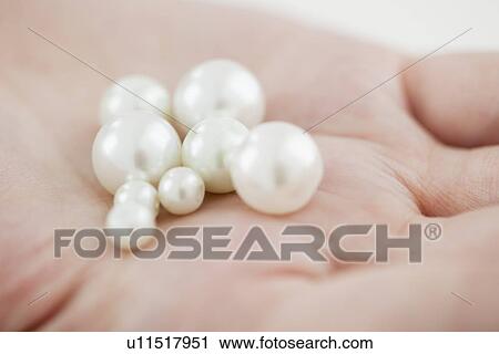 Stock Image - Woman holding pearl. Fotosearch