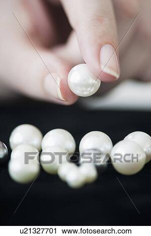 Stock Image - Woman holding pearl. Fotosearch