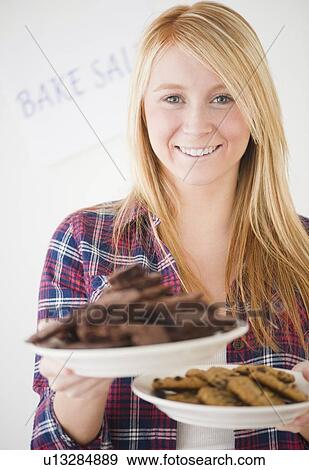 Woman holding plates full of cakes View Large Photo Image Stock Photo - Woman holding plates full of cakes. Fotosearch