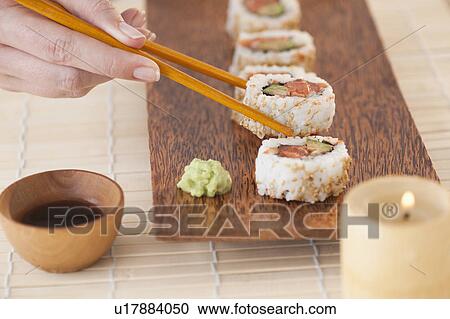 Woman holding sushi by chopsticks View Large Photo Image Stock Image - Woman holding sushi by chopsticks. Fotosearch