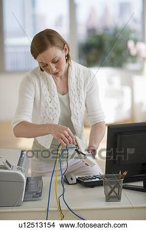 Picture - Woman installing router at home office. Fotosearch