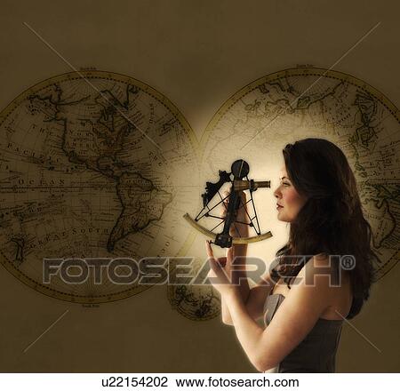 Stock Image - Woman looking through antique sextant, world map in background. Fotosearch