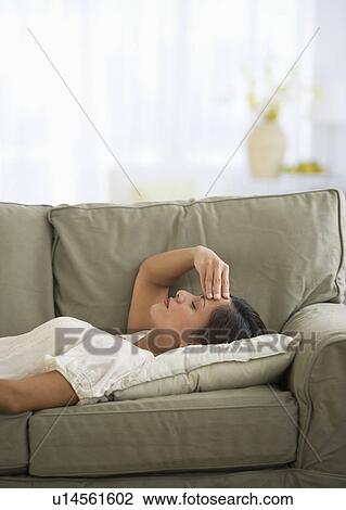 Woman lying on sofa with headache View Large Photo Image Stock Image - Woman lying on sofa with headache. Fotosearch