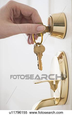 Stock Photography - Woman opening door lock. Fotosearch