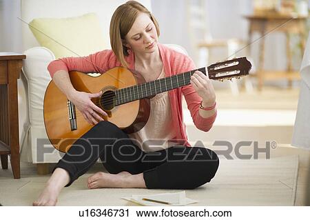 Stock Image - Woman playing guitar. Fotosearch