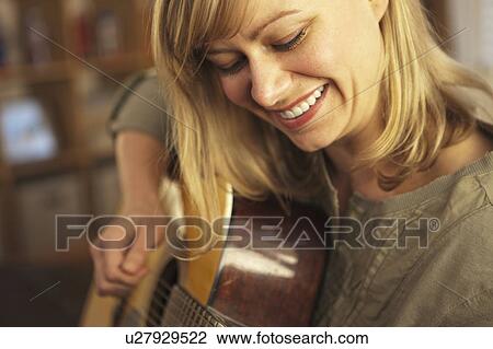 Stock Image - Woman playing guitar. Fotosearch