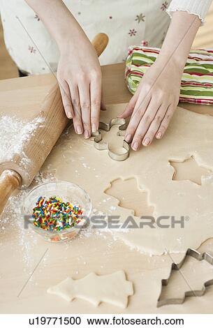 Stock Image - Woman preparing biscuits with pastry cutter. Fotosearch