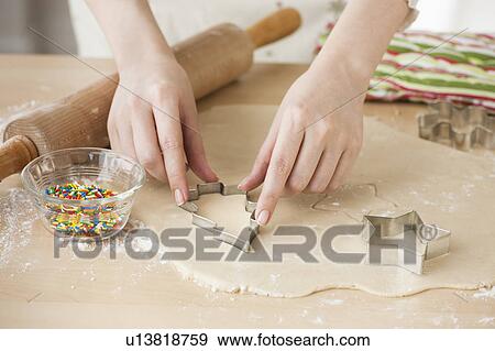 Stock Photo - Woman preparing biscuits with pastry cutter. Fotosearch