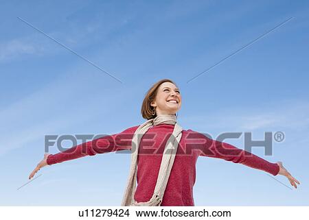Woman raising hands against sky View Large Photo Image Picture - Woman raising hands against sky. Fotosearch