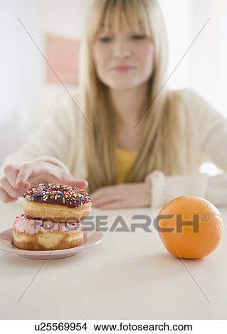 Picture - Woman reaching for donut. Fotosearch