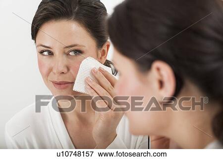 Stock Photo - Woman removing make-up in bathroom. Fotosearch