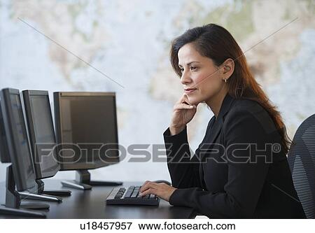 Woman working at desk with monitors View Large Photo Image Stock Photo - Woman working at desk with monitors. Fotosearch