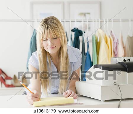 Stock Photo - Young businesswoman doing paperwork. Fotosearch