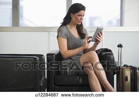 Young businesswoman using digital tablet at airport View Large Photo Image Stock Photo - Young businesswoman using digital tablet at airport. Fotosearch