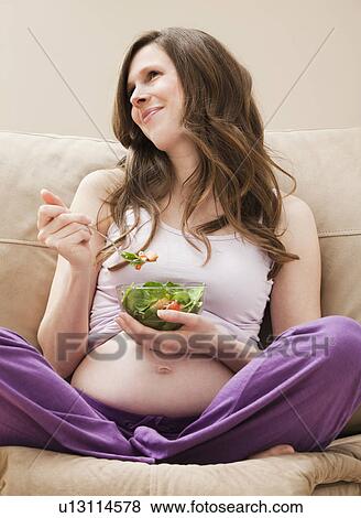 Young pregnant woman eating salad View Large Photo Image Stock Photo - Young pregnant woman eating salad. Fotosearch