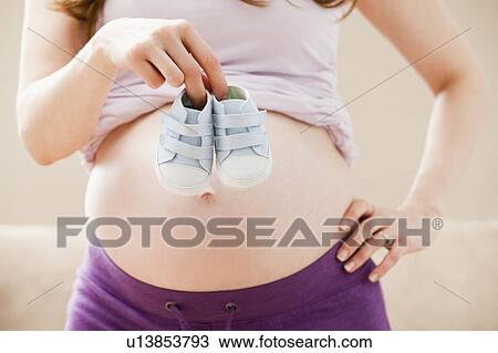 Young pregnant woman holding baby boots View Large Photo Image Stock Image - Young pregnant woman holding baby boots. Fotosearch