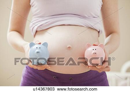 Young pregnant woman holding blue and pink piggybanks View Large Photo Image Stock Image - Young pregnant woman holding blue and pink piggybanks. Fotosearch