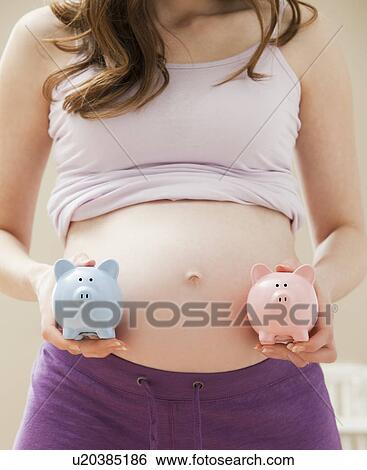 Young pregnant woman holding blue and pink piggybanks View Large Photo Image Stock Photograph - Young pregnant woman holding blue and pink piggybanks. Fotosearch